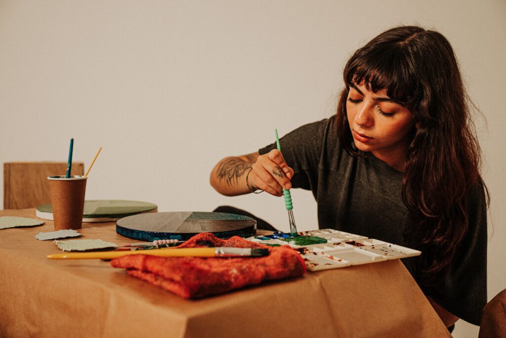Female artist painting in a studio with a brush and paint palette