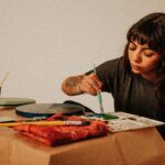 Female artist painting in a studio with a brush and paint palette