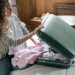 Woman packing a suitcase on a bed before a trip